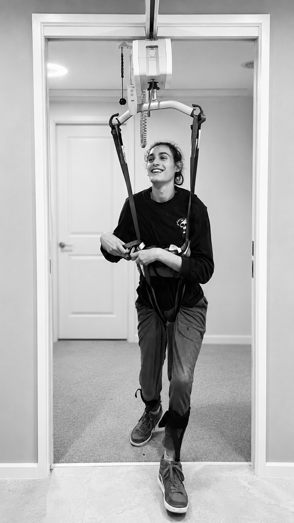 Participant standing with the support of a ceiling hoist